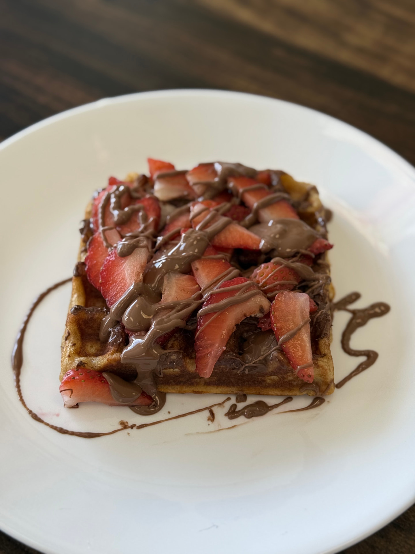 Berry Delight waffle layered with Nutella, fresh strawberries and Belgian chocolate drizzle